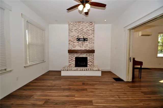 a view of an empty room with a fireplace and a window