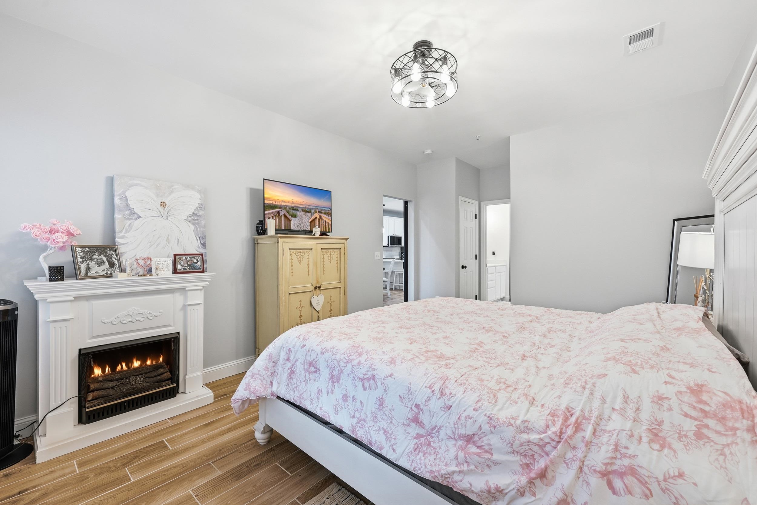 5810 Longwood Drive, Unit 303 Murrells Inlet, SC 29576 - Photo 12 of 27 Bedroom featuring wood tiled floors and a lit fireplace