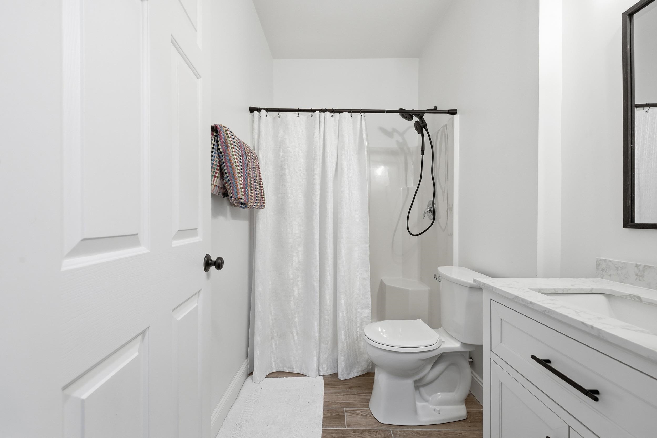 5810 Longwood Drive, Unit 303 Murrells Inlet, SC 29576 - Photo 13 of 27 Full bathroom featuring curtained shower, vanity, and wood finish floors