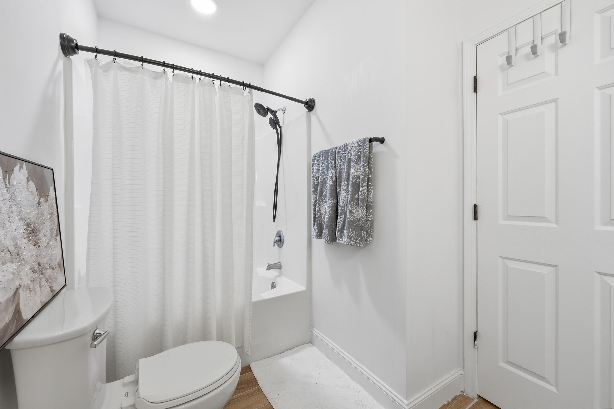 5810 Longwood Drive, Unit 303 Murrells Inlet, SC 29576 - Photo 14 of 27 Full bathroom featuring shower / tub combo with curtain and wood finished floors
