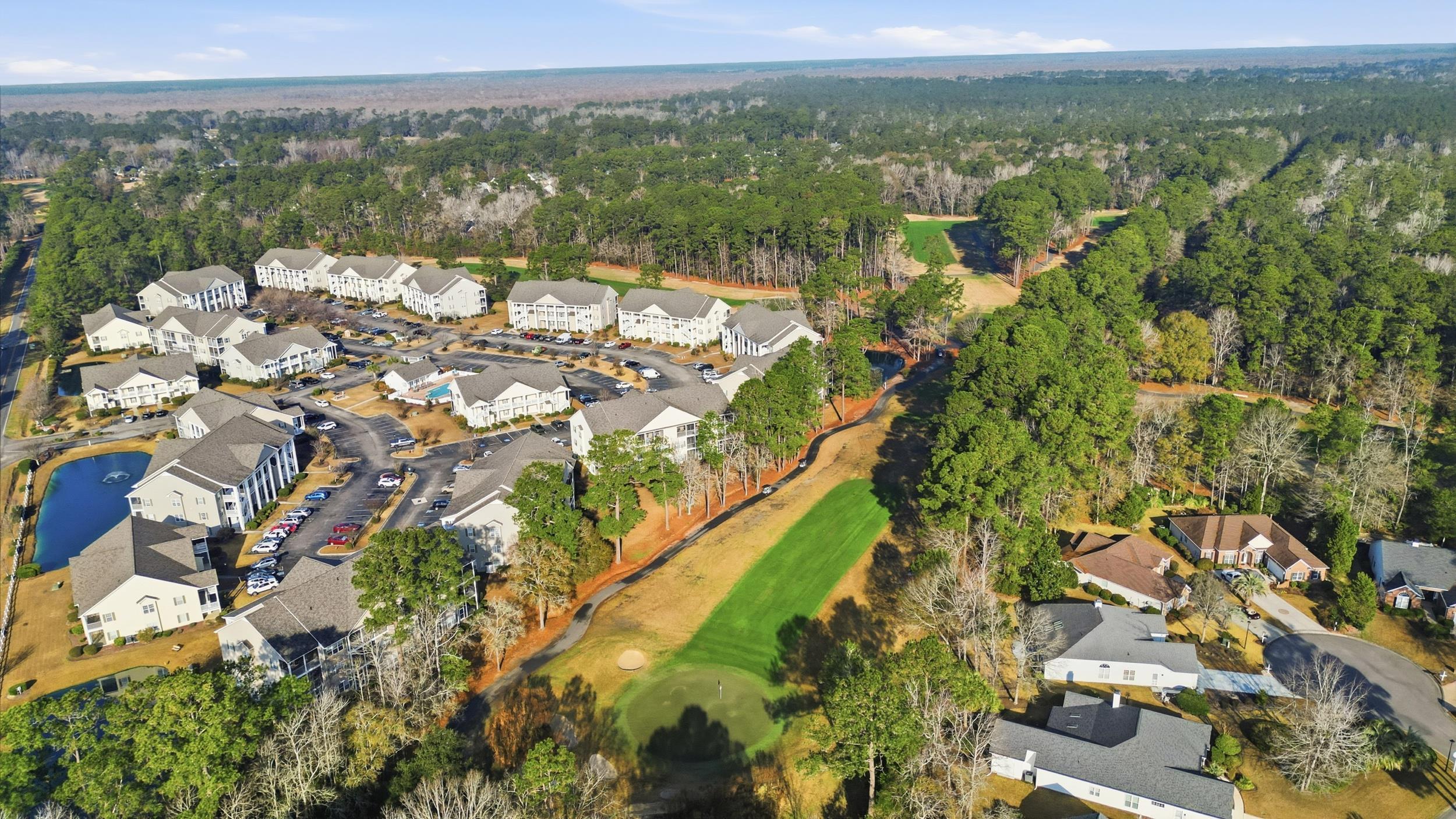 5810 Longwood Drive, Unit 303 Murrells Inlet, SC 29576 - Photo 21 of 27 Aerial view of property and surrounding area featuring a golf club and nearby suburban area