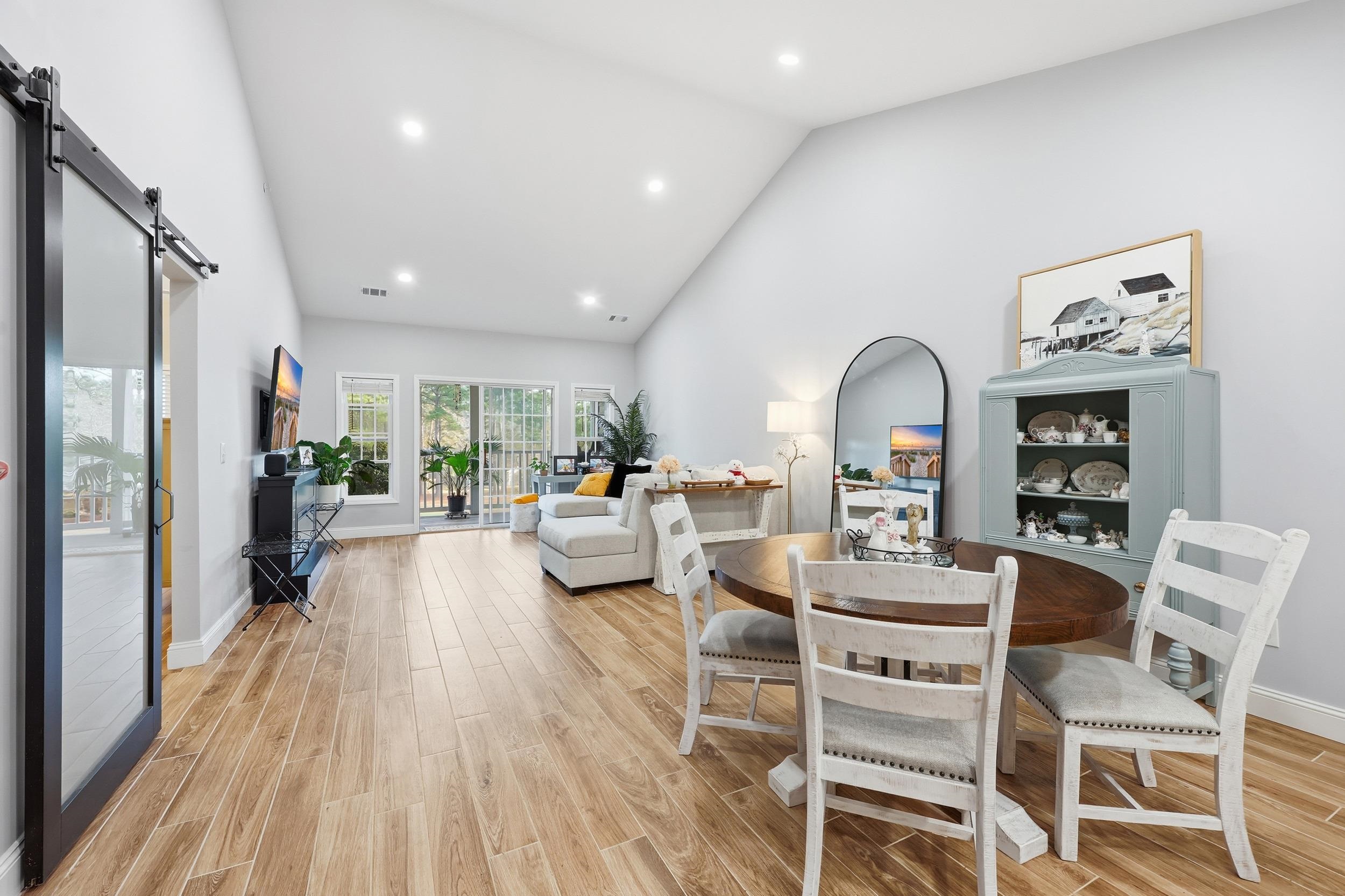 5810 Longwood Drive, Unit 303 Murrells Inlet, SC 29576 - Photo 5 of 27 Dining space featuring a barn door, wood finish floors, high vaulted ceiling, and recessed lighting