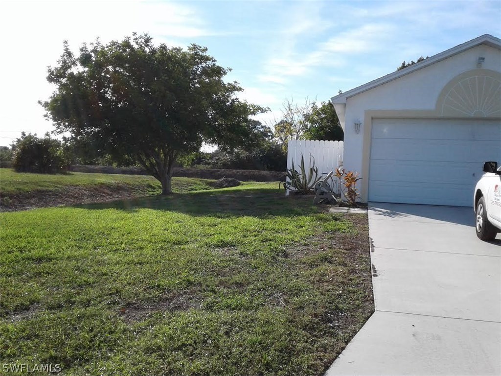 210 Roat Street Lehigh Acres, FL 33936 - Photo 2 of 9 a backyard of a house with lots of green space