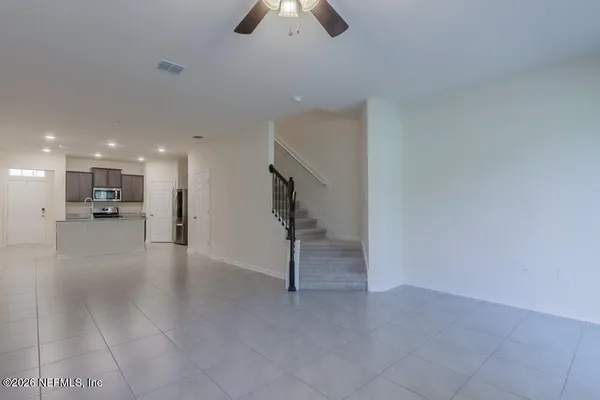 a view of an empty room and kitchen view