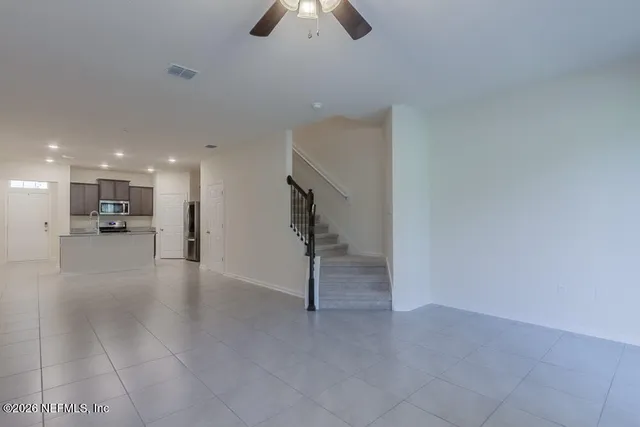 a view of an empty room and kitchen view