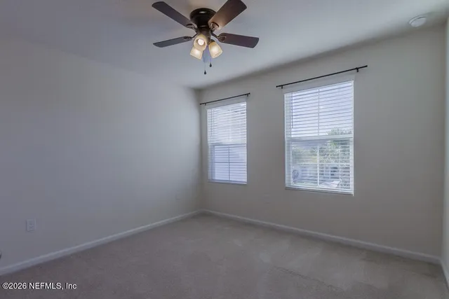 an empty room with a empty space and a ceiling fan