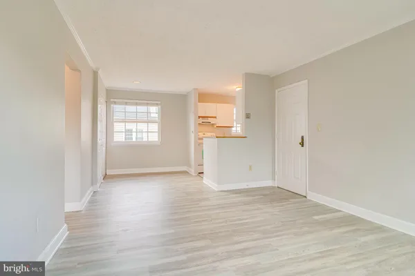 a view of empty room with wooden floor and window