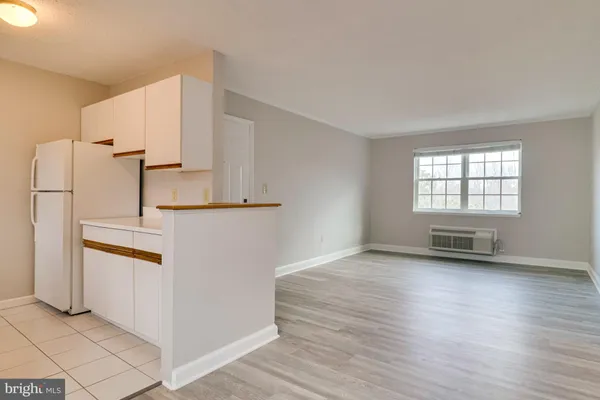 an empty room with wooden floor and white walls