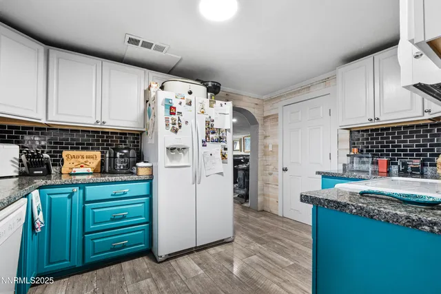 a kitchen with granite countertop a refrigerator and a stove top oven