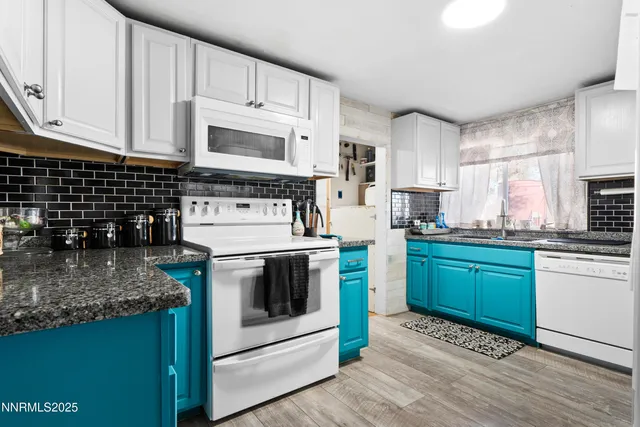a kitchen with granite countertop a sink a stove and cabinets