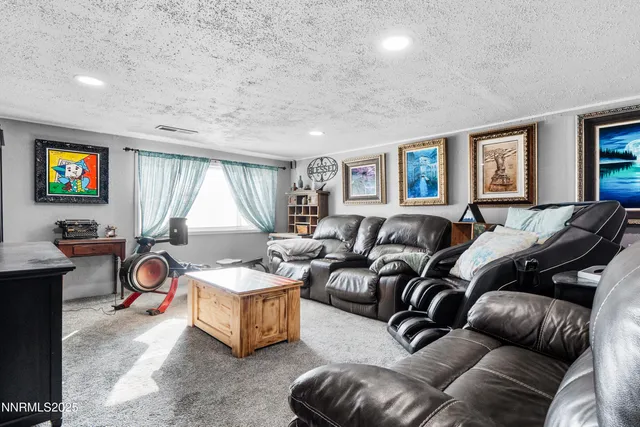 a living room with furniture a large window and a potted plant