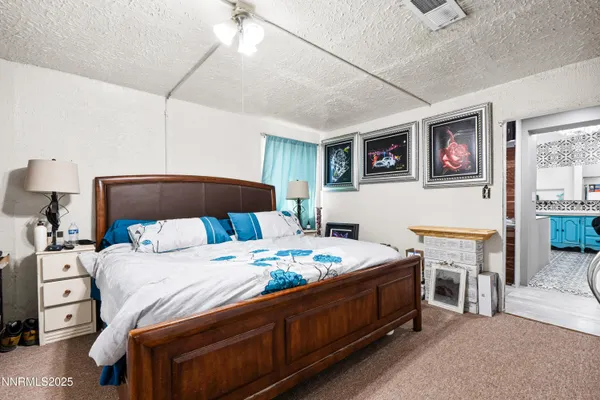 a bedroom with a bed a flat screen tv and a dresser