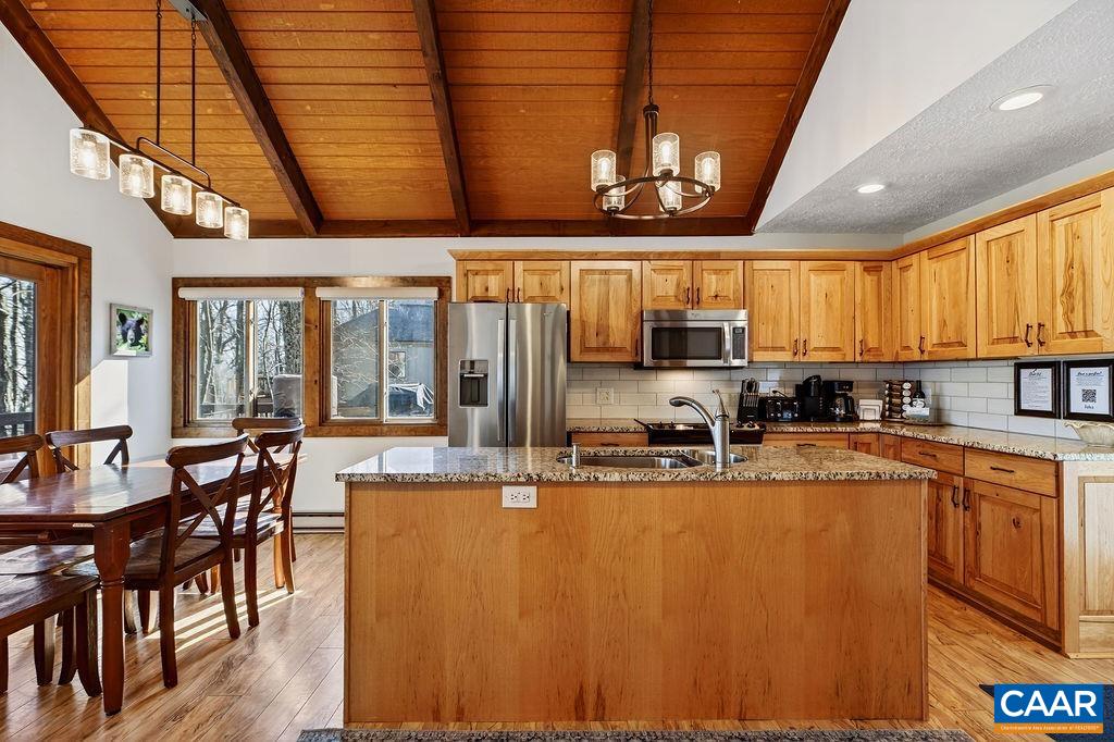96 Squirrel Tree Lane Roseland, VA 22967 - Photo 12 of 46 a kitchen with stainless steel appliances granite countertop a stove top oven a sink dishwasher a dining table and chairs with wooden floor