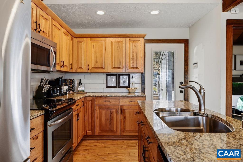 96 Squirrel Tree Lane Roseland, VA 22967 - Photo 14 of 46 a kitchen with stainless steel appliances granite countertop a sink stove and cabinets