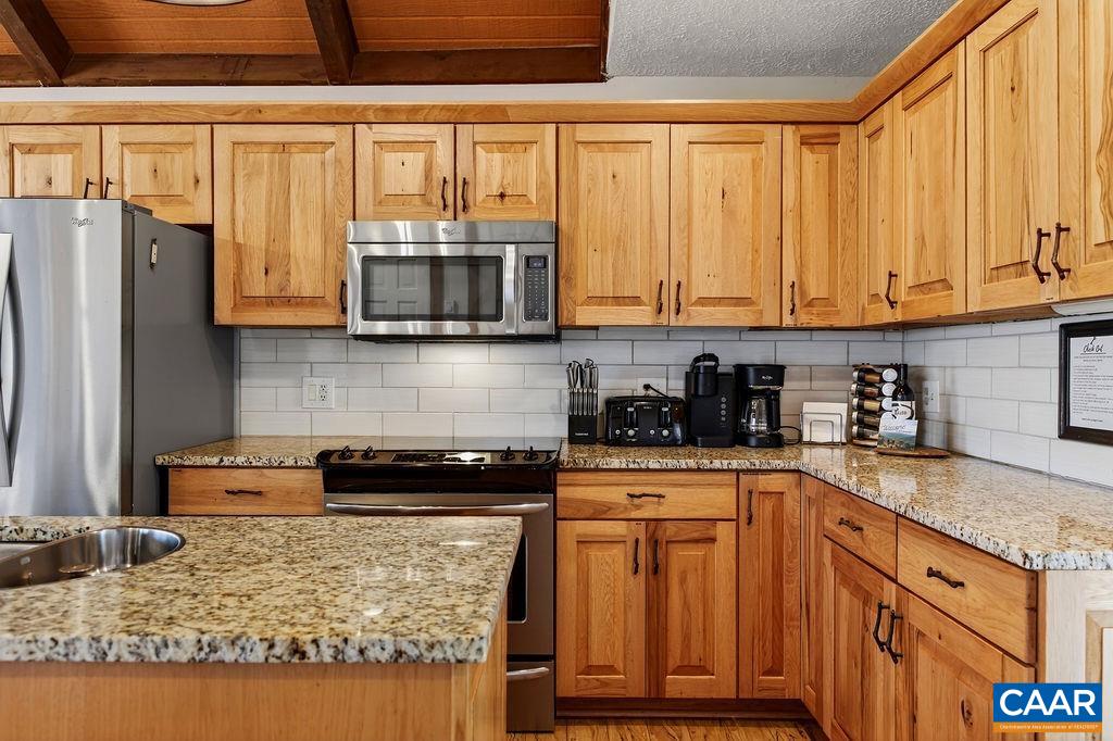 96 Squirrel Tree Lane Roseland, VA 22967 - Photo 15 of 46 a kitchen with granite countertop wooden cabinets and a stove top oven