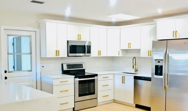 a kitchen with white cabinets and stainless steel appliances