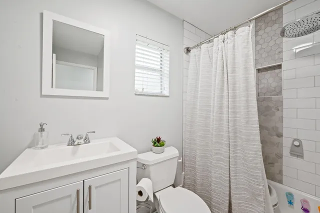 a bathroom with a sink a toilet and shower curtain