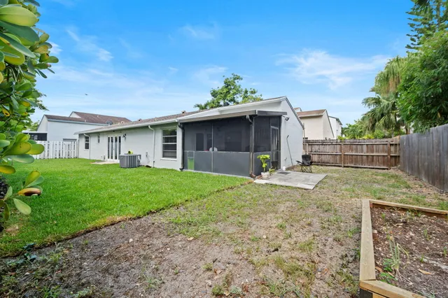 a view of a house with backyard and a garden