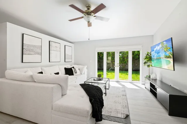 a living room with furniture and a large window with garden view
