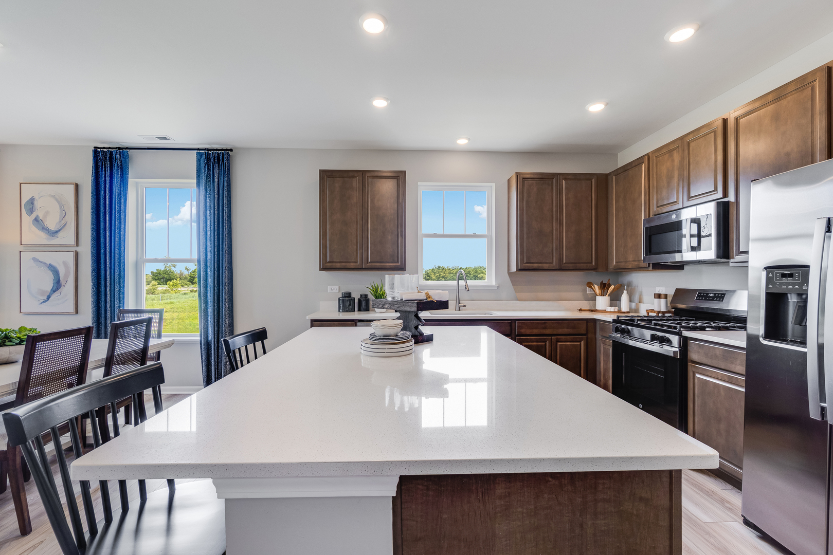 4245 Meadowridge Road Woodstock, IL 60098 - Photo 10 of 21 a kitchen with kitchen island granite countertop a stove a sink a microwave a dining table and chairs
