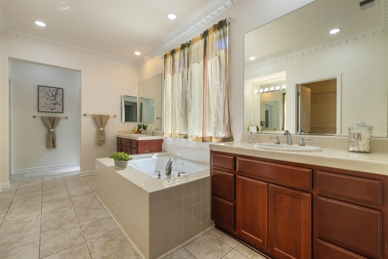 481 Keys Court Tracy, CA 95377 - Photo 22 of 45 a spacious bathroom with a double vanity sink a mirror and a bathtub