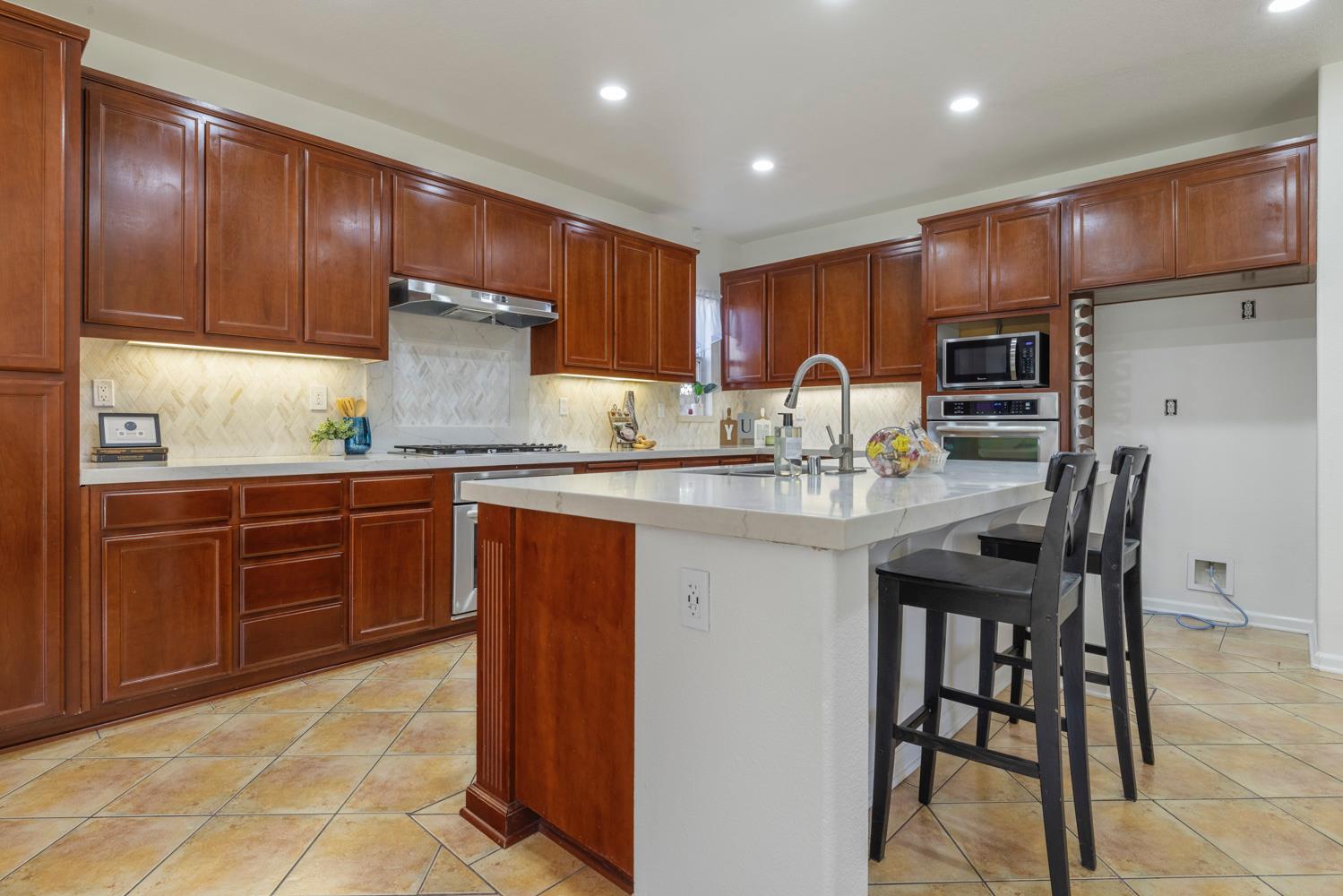 481 Keys Court Tracy, CA 95377 - Photo 8 of 45 a kitchen with stainless steel appliances granite countertop wooden cabinets a refrigerator and a sink