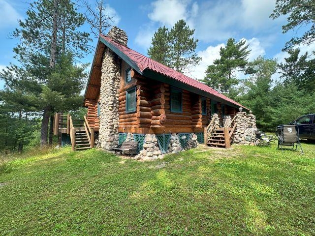 3547 Norway Lane Ely, MN 55731 - Photo 19 of 31 View of home's exterior featuring stairway, a lawn, log exterior, and a chimney