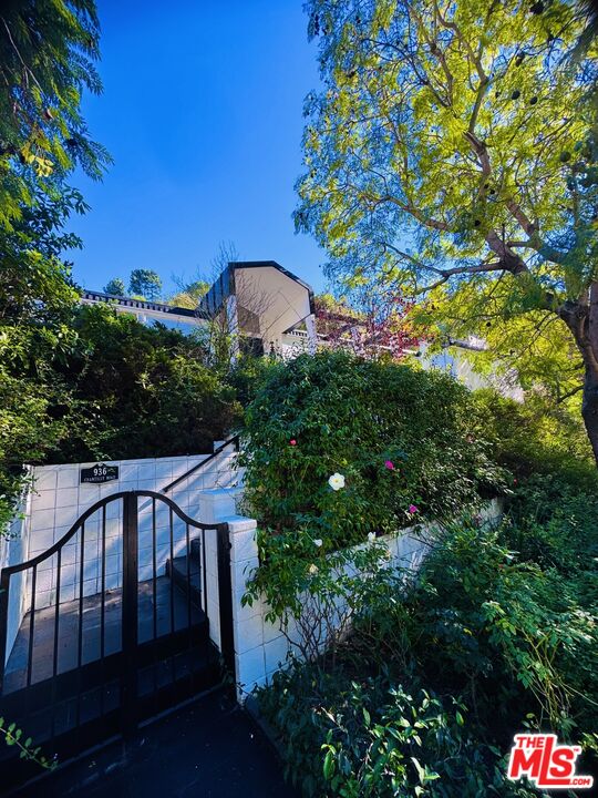 936 Chantilly Road Los Angeles, CA 90077 - Photo 16 of 25 a view of a house with a backyard and a tree