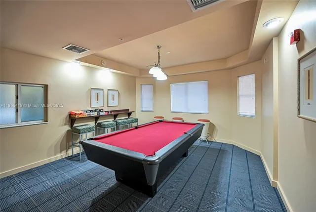 a room with pool table and windows