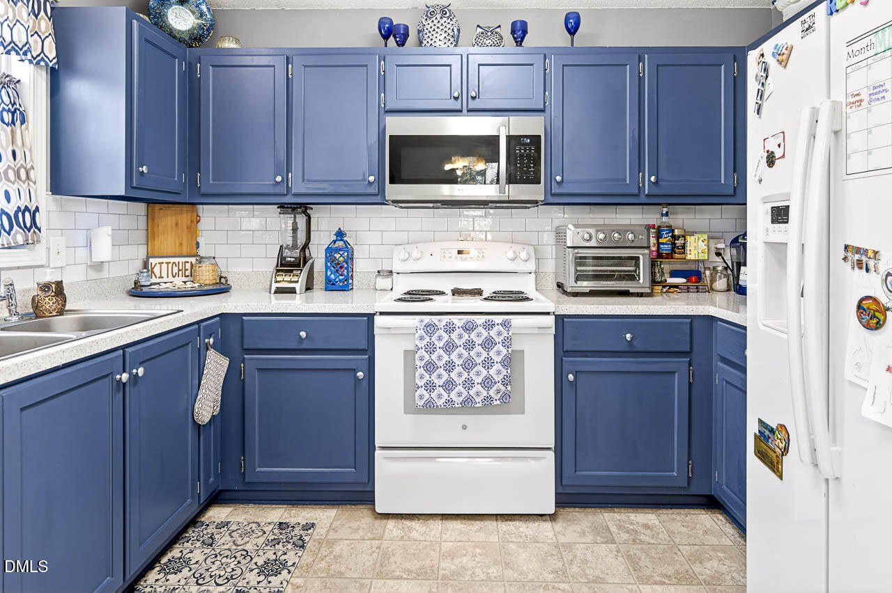 6668 Beaver Ridge Court Snow Camp, NC 27349 - Photo 19 of 38 a kitchen with stainless steel appliances granite countertop a refrigerator stove and sink