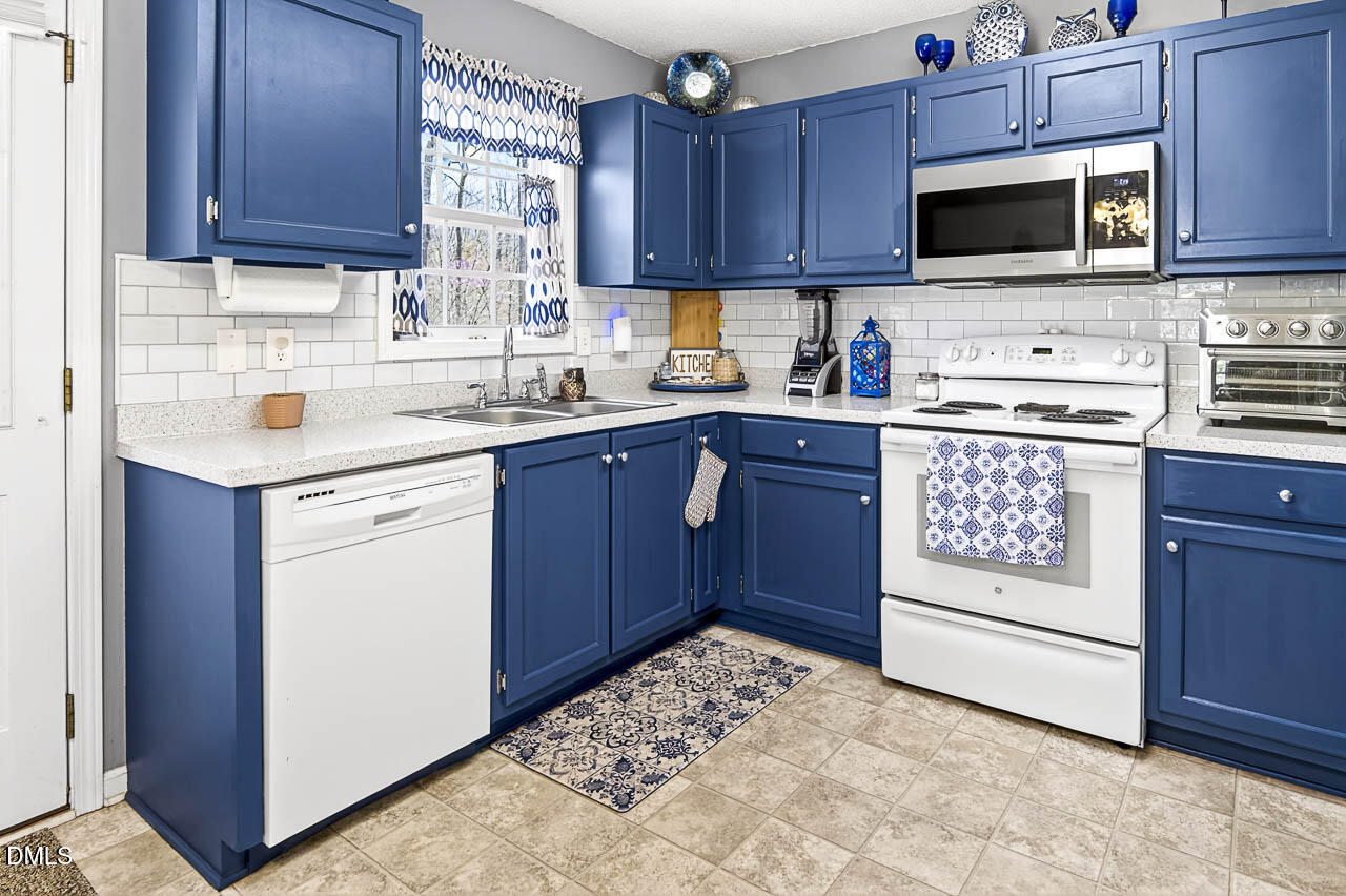 6668 Beaver Ridge Court Snow Camp, NC 27349 - Photo 20 of 38 a kitchen with stainless steel appliances granite countertop a stove microwave and cabinets