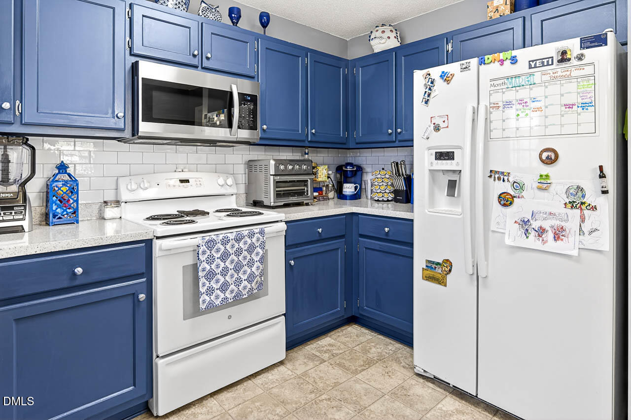 6668 Beaver Ridge Court Snow Camp, NC 27349 - Photo 21 of 38 a kitchen with stainless steel appliances a refrigerator stove and microwave