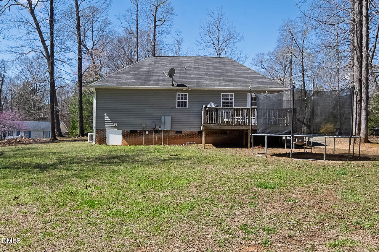 6668 Beaver Ridge Court Snow Camp, NC 27349 - Photo 6 of 38 a front view of a house with a garden and trees