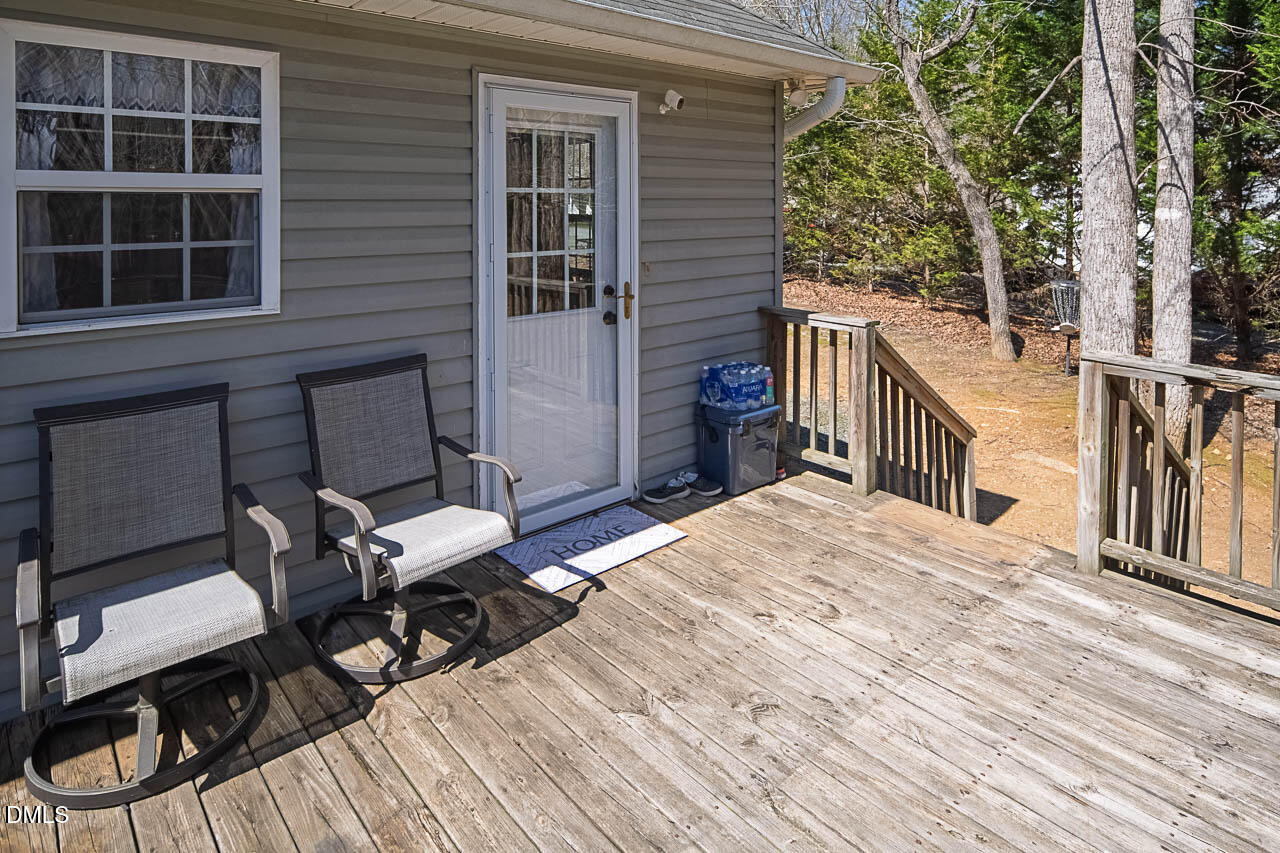 6668 Beaver Ridge Court Snow Camp, NC 27349 - Photo 10 of 38 a view of a deck with couches table and chairs and wooden floor