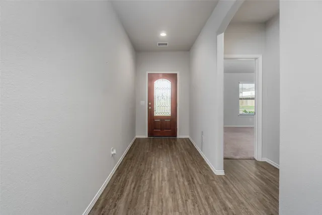 a view of a hallway with wooden floor