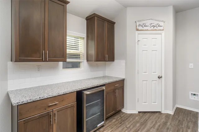 a kitchen with stainless steel appliances granite countertop a sink and wooden floor