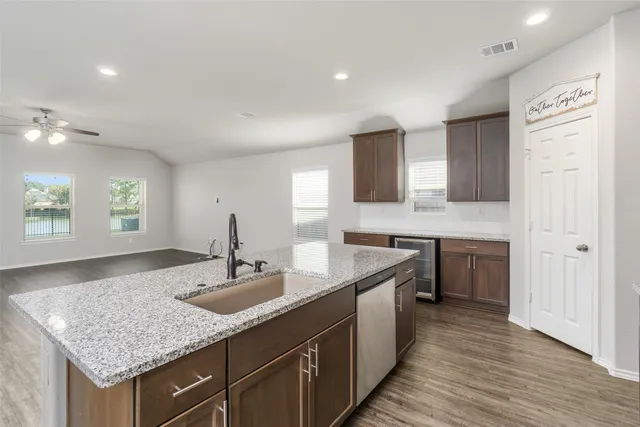 a kitchen with granite countertop kitchen island a sink appliances and a counter space