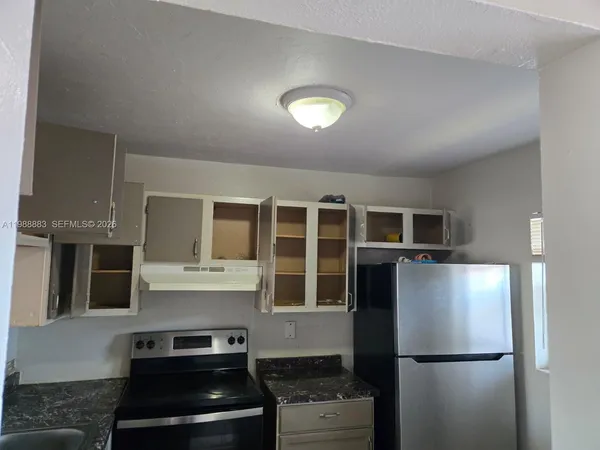 a kitchen with a refrigerator and a stove top oven