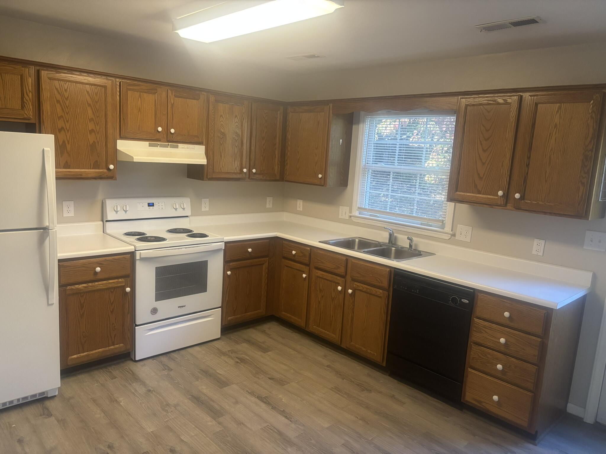 a kitchen with a white stove top oven sink and cabinets