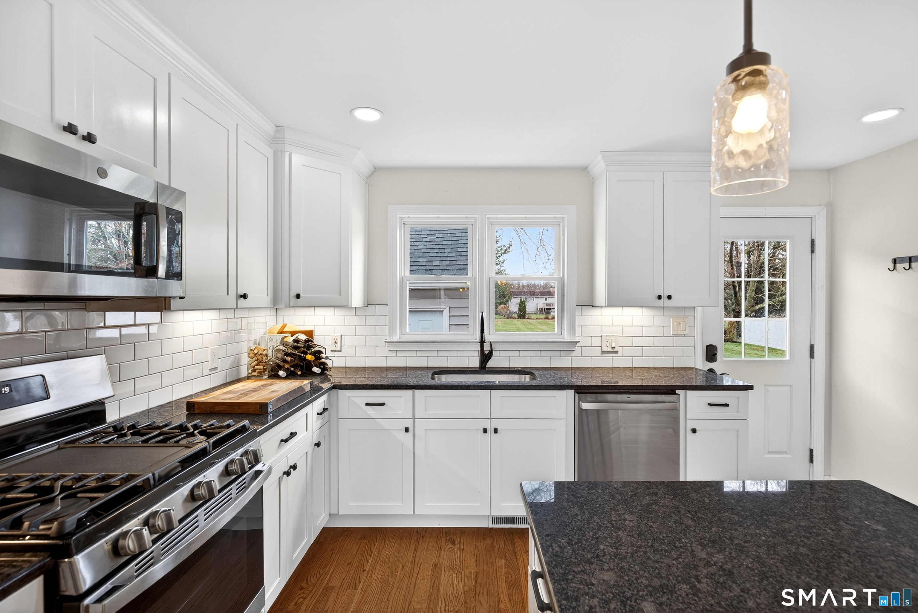 45 Walnut Street Milford, CT 06461 - Photo 16 of 39 a kitchen with stainless steel appliances granite countertop a stove a sink dishwasher and a microwave oven with wooden cabinets