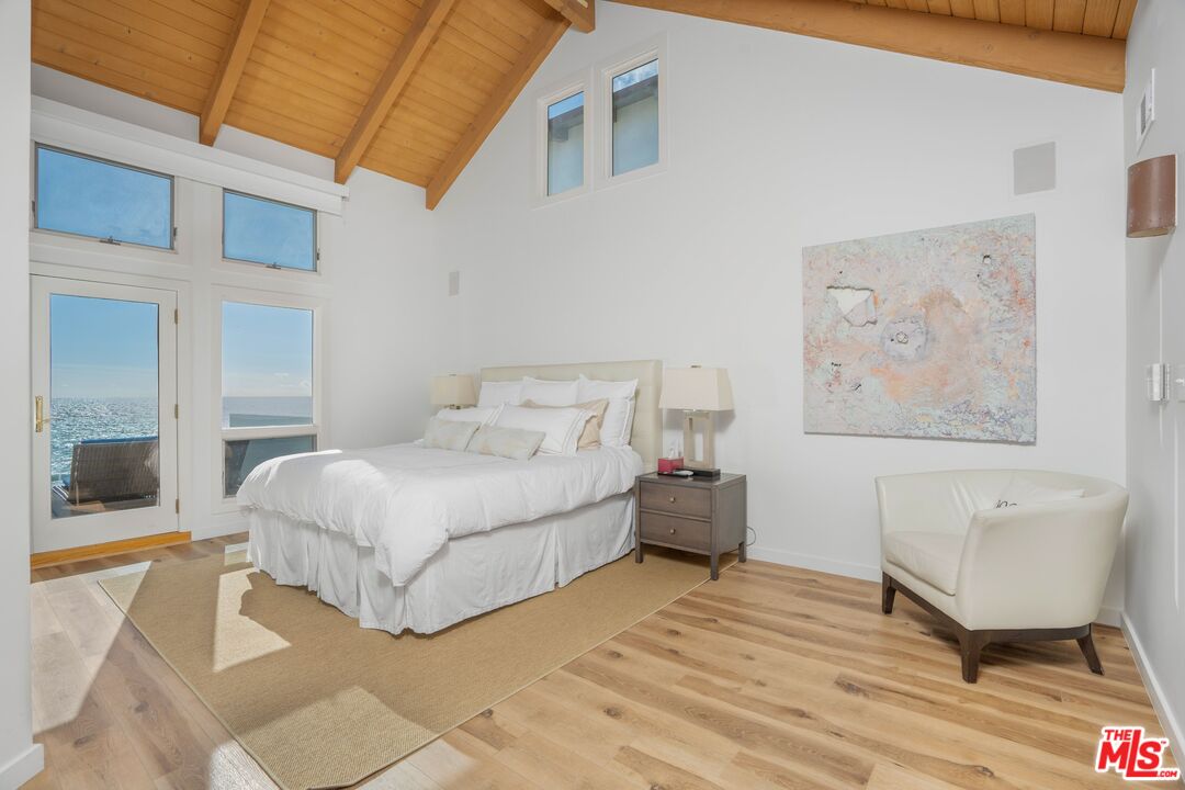 24456 Malibu Road Malibu, CA 90265 - Photo 13 of 33 a spacious bedroom with a bed a rug and wooden floor