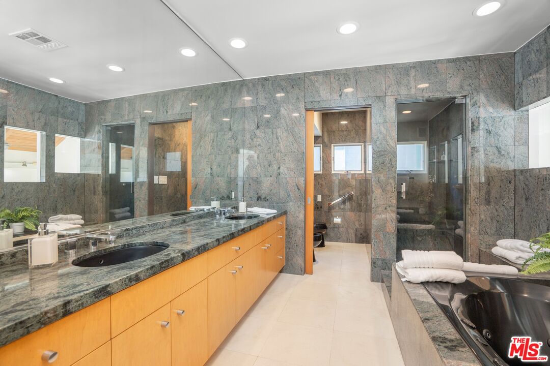 24456 Malibu Road Malibu, CA 90265 - Photo 15 of 33 a bathroom with a granite countertop sink mirror and a bath tub