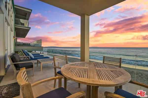 a view of a balcony with table and chairs and wooden floor