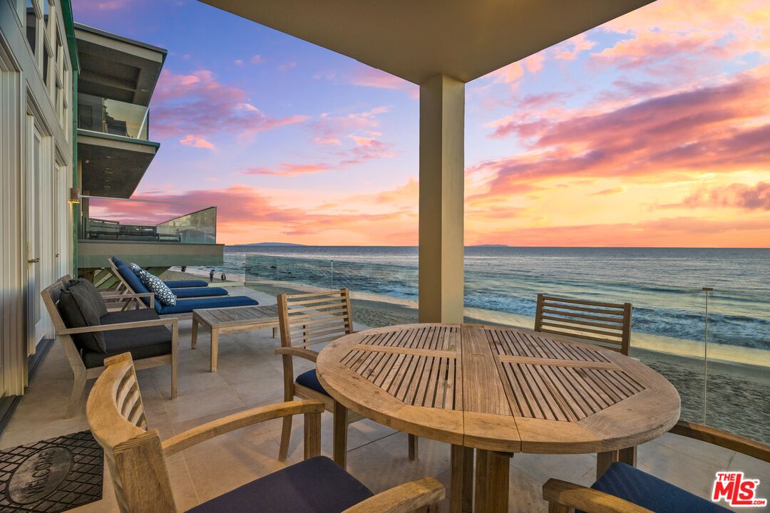 24456 Malibu Road Malibu, CA 90265 - Photo 2 of 33 a view of a balcony with table and chairs and wooden floor