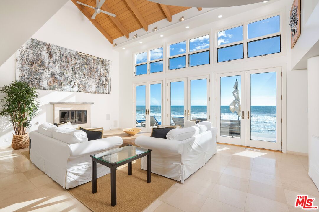 24456 Malibu Road Malibu, CA 90265 - Photo 4 of 33 a living room with furniture large windows and a fireplace
