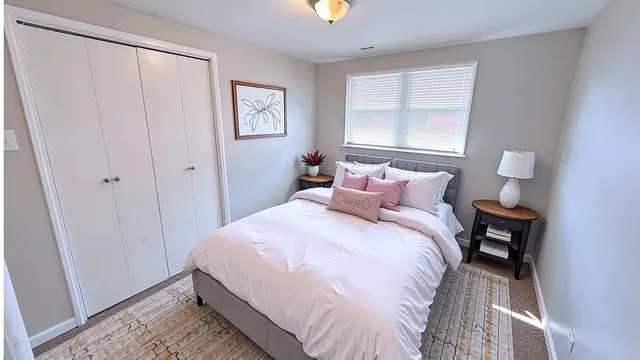 a view of a house with a small yard and a large tree