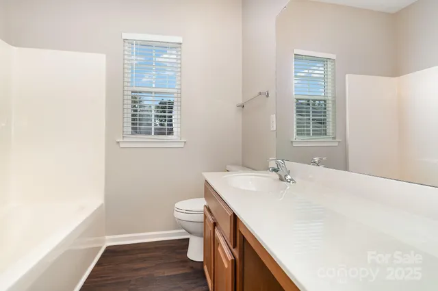 a bathroom with a sink a toilet and a window