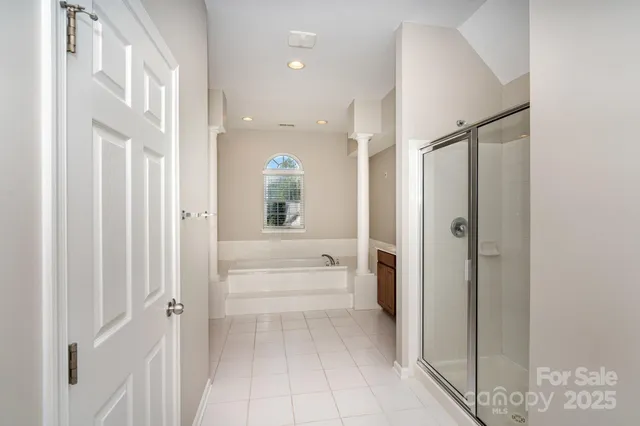 a bathroom with a glass shower door a bathtub a sink and a mirror