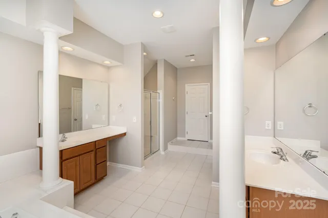 a spacious bathroom with a tub sink and mirror