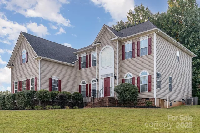 a front view of a house with garden and trees